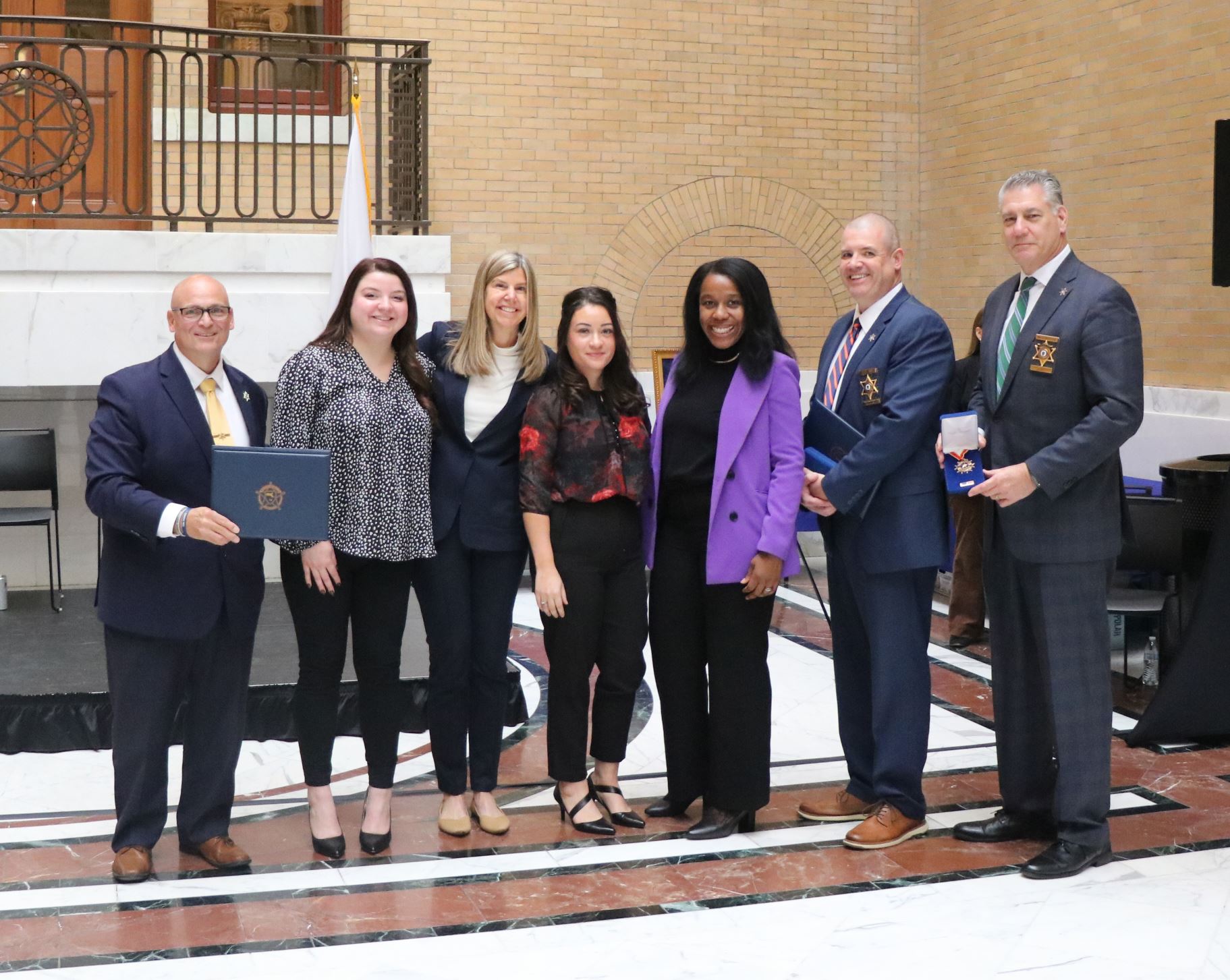Members of the Family Support Services Unit & Sheriff Koutoujian accept an award at the State House.