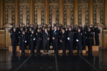 Posed photo of the 49th Basic Training Academy on stage with command and training academy staff.
