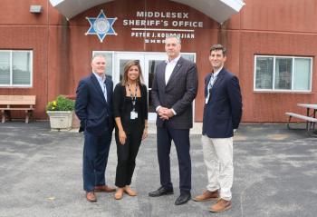 Four people stand outside the front door of the Middlesex Jail &amp; House of Correction