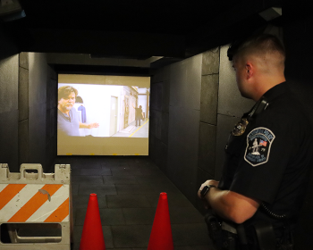 A member of the Lexington Police Department goes through a scenario inside the Middlesex Sheriff's Office Mobile Training Center on July 21, 2022.