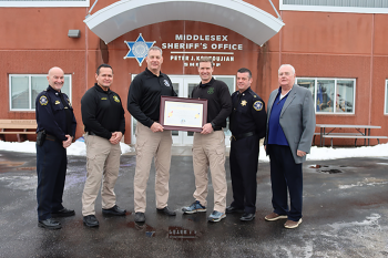 Members of the MSO hold the ACA accreditation certificate outside the Middlesex Jail &amp; House of Correction.
